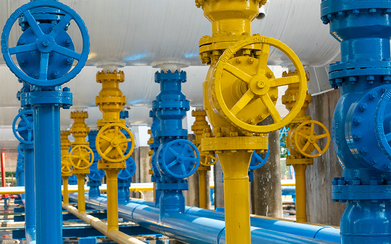 Blue and yellow globe valves installed in industrial piping.