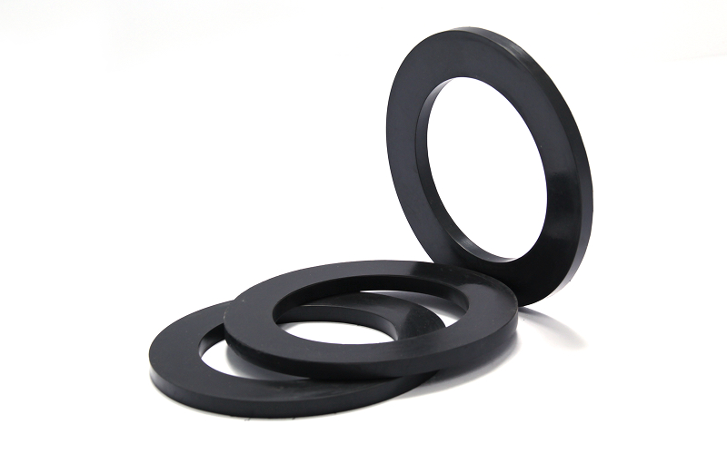 A small pile of black rubber ring gaskets or washers shown against a white background.