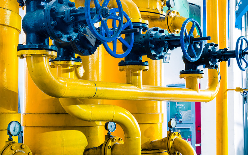 Complex industrial piping network with multiple manual wheel valves.