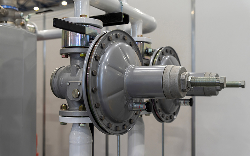 Gas pressure regulators on pipeline with diaphragm housings, adjustment bolts.